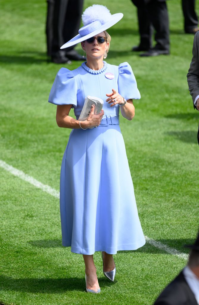Zara Tindall on grass in blue dress and hat
