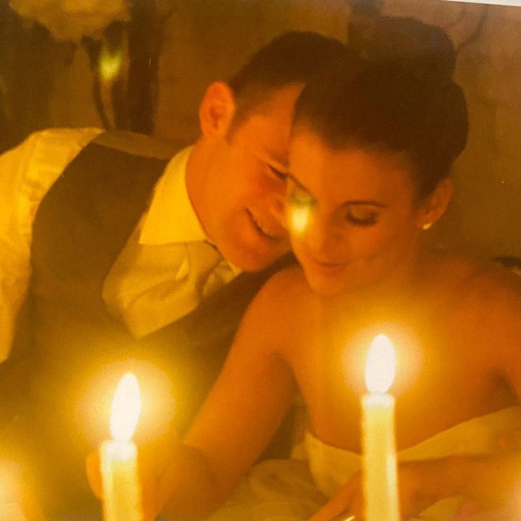 Coleen and Wayne Rooney whispering with candles on their wedding day