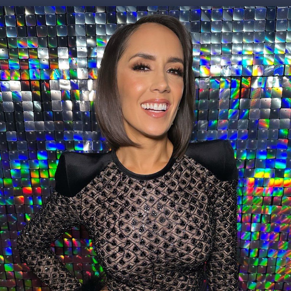 Janette Manrara in front of shiny backdrop