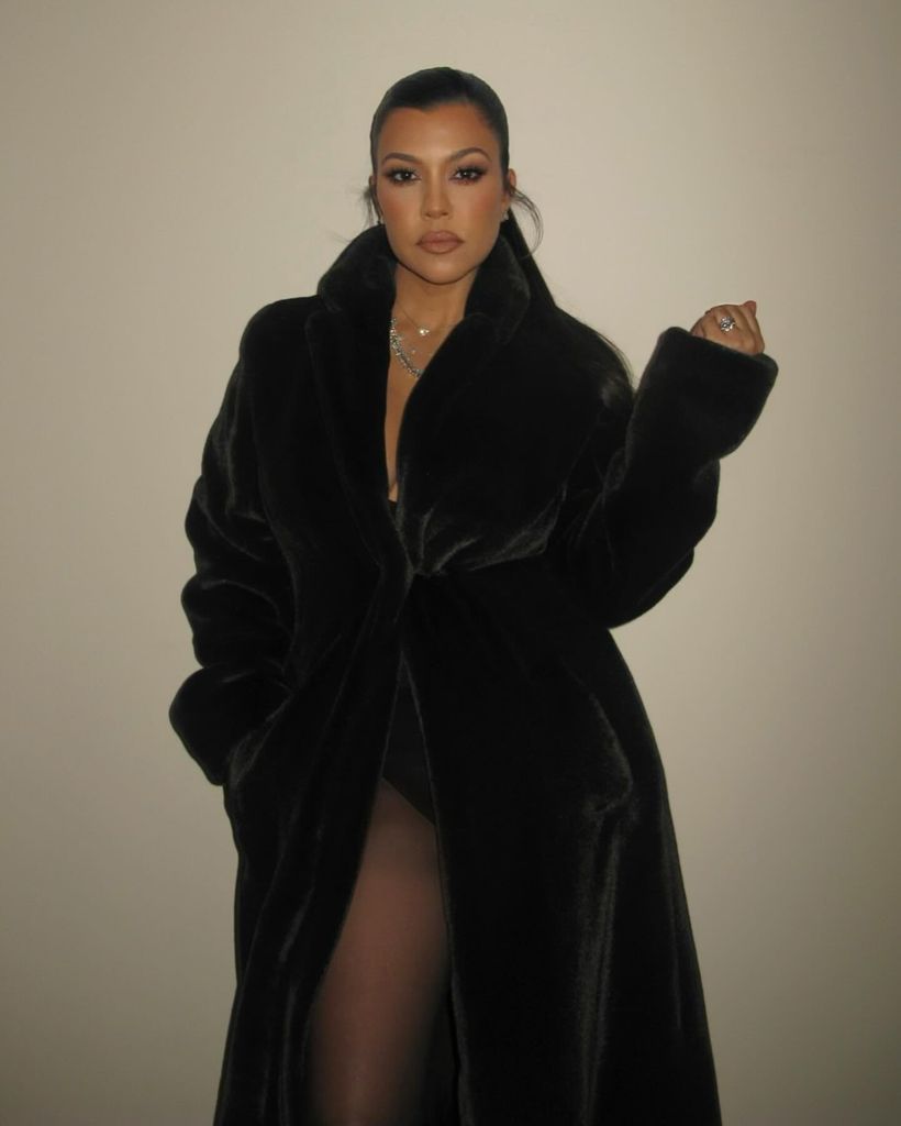 Kourtney Kardashian usando collant preto e casaco de pele