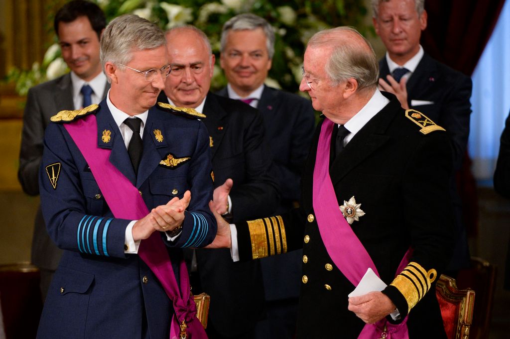 King Albert II of Belgium (R) congratulate Crown Prince Philippe of Belgium during the signing of the abdication treaty