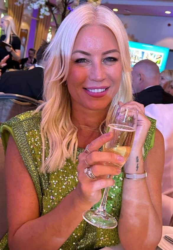 Denise van Outen holding a champagne glass