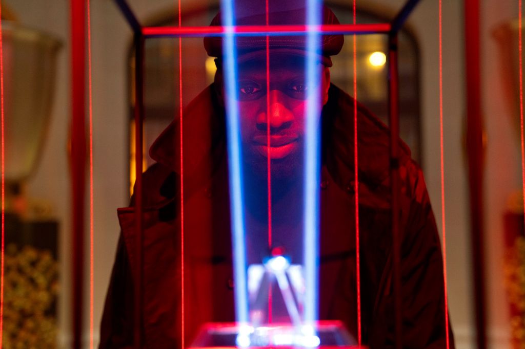 Still from Lupin with Omar Sy staring at a diamond