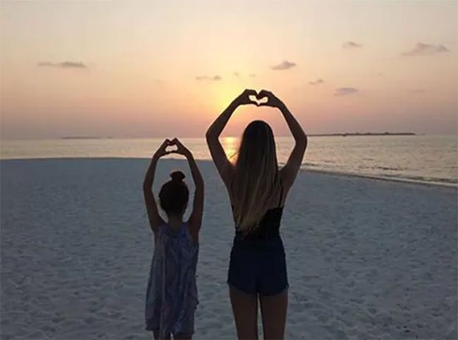 Tess Daly daughters stretch arms high on beach