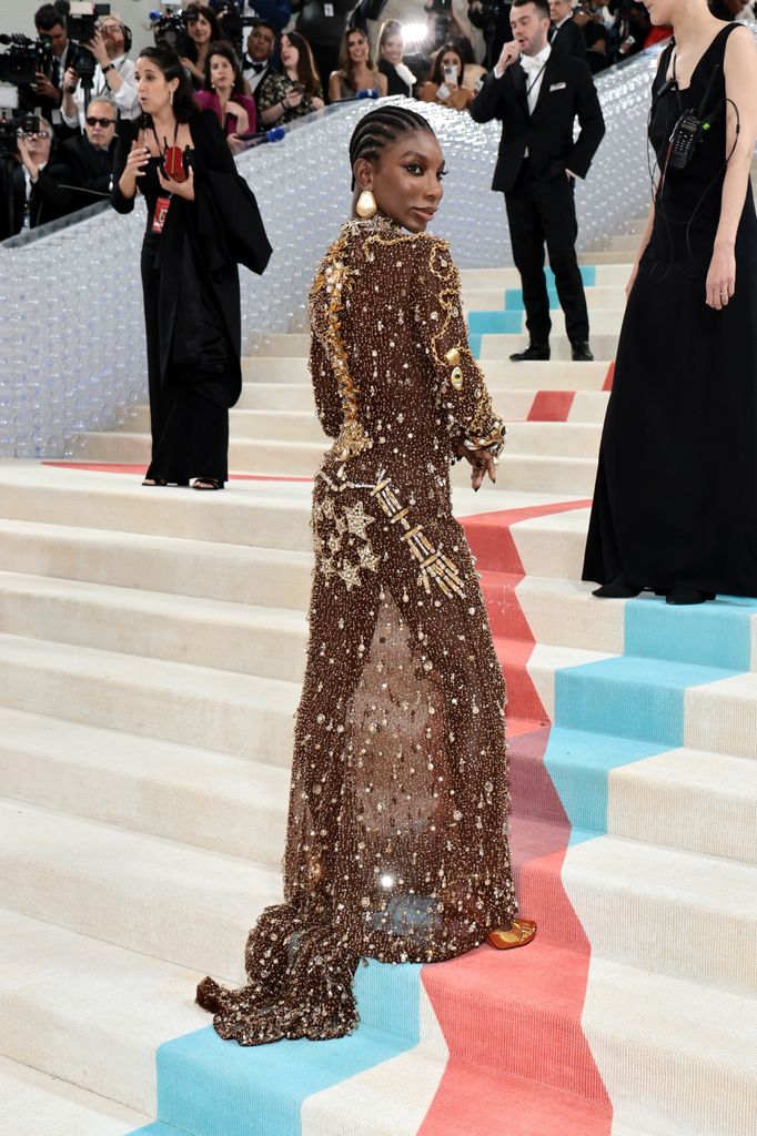 Michaela Coel attends The 2023 Met Gala Celebrating "Karl Lagerfeld: A Line Of Beauty in gold dress