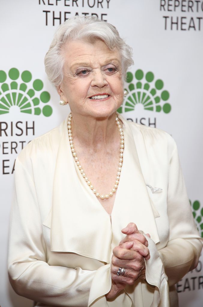 Angela Lansbury in a cream outfit with a pearl necklace