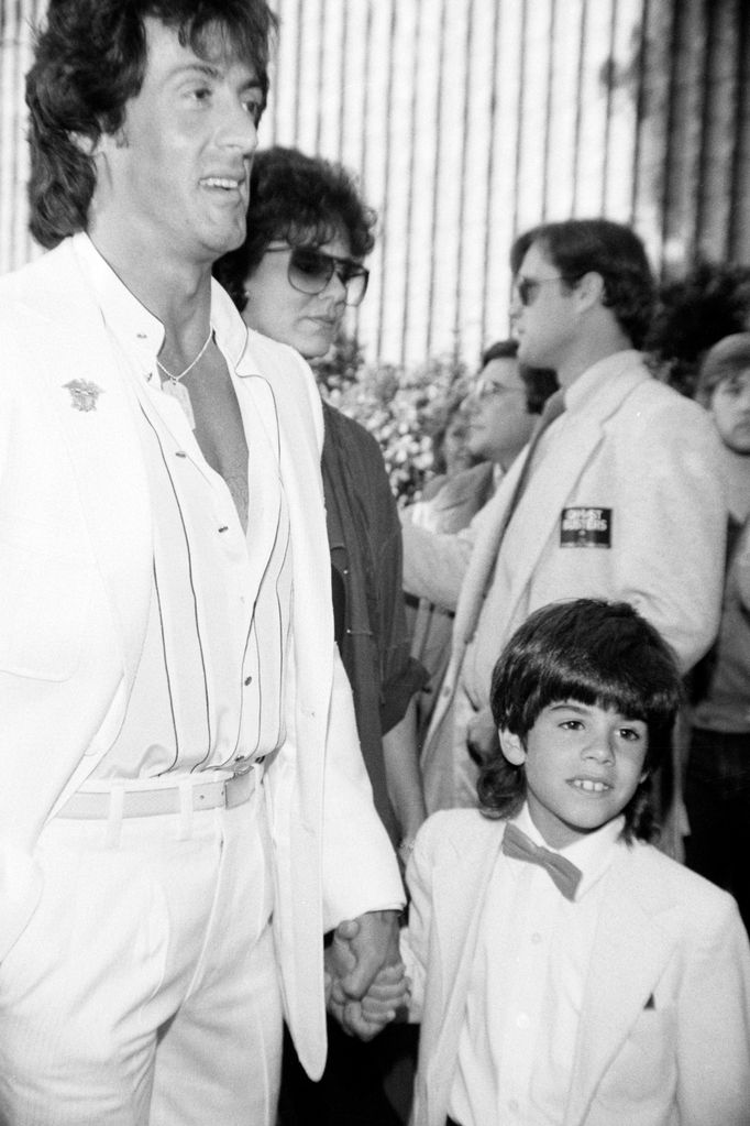 (L-R, foreground) Sylvester Stallone and son Seargeoh Stallone attend an event, benefitting Saint John's Hospital in Santa Monica, at Avco Theaters in the Westwood neighborhood of Los Angeles, California, on June 7, 1984. (Photo by Pierre-Gilles Vidoli/Variety/Penske Media via Getty Images)