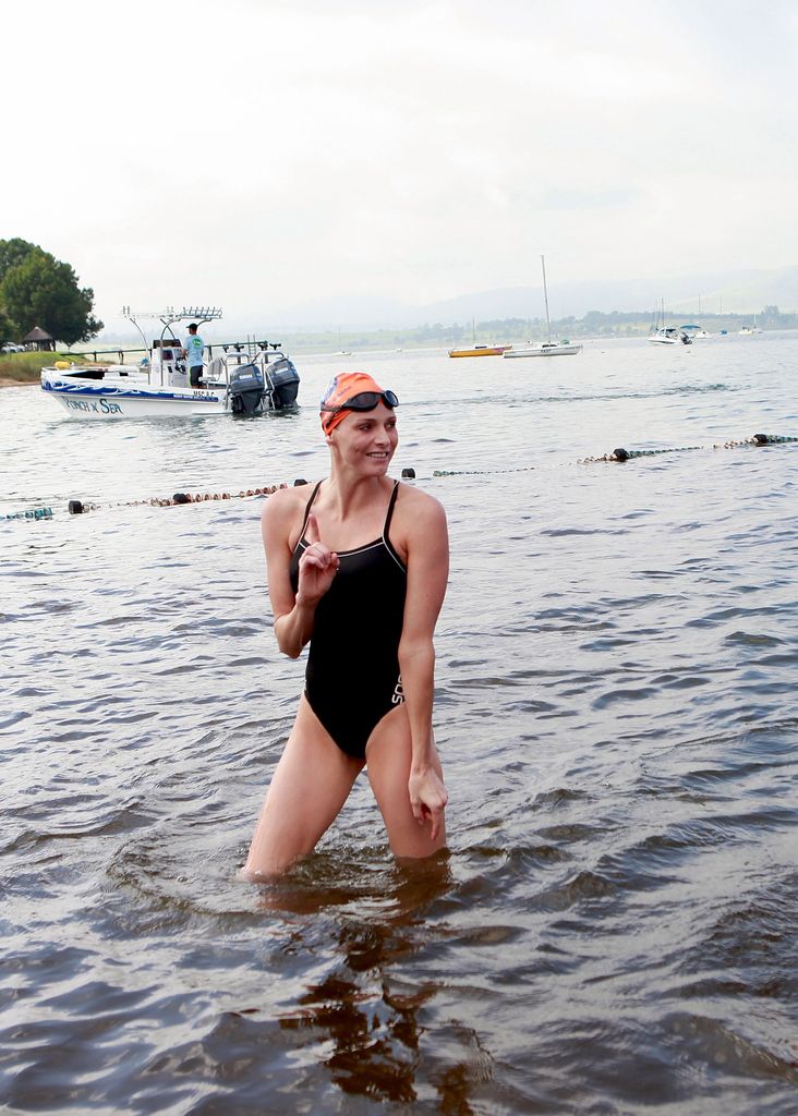 Princess Charlene in a black swimsuit emerging from the sea