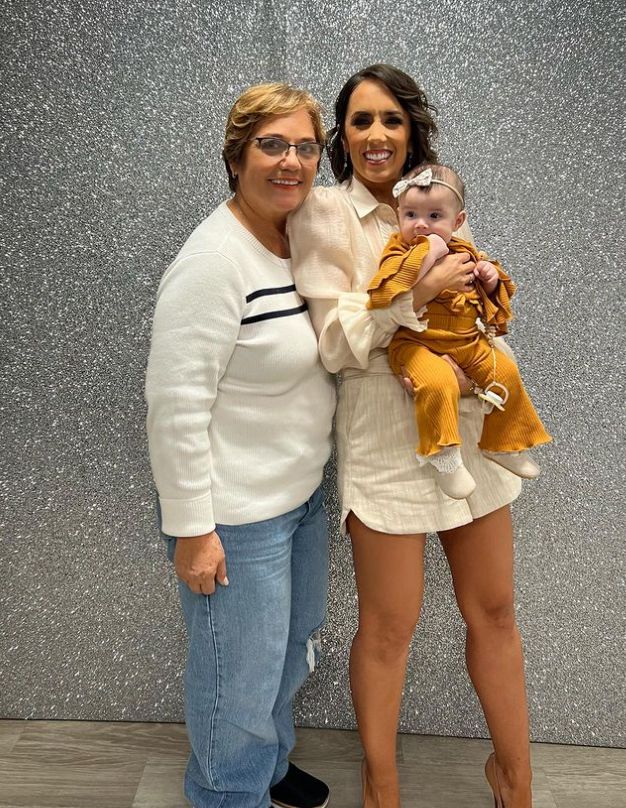 Janette Manrara holding a baby and standing with her mum