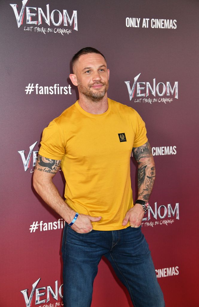 Tom Hardy in a yellow shirt and blue denim jeans