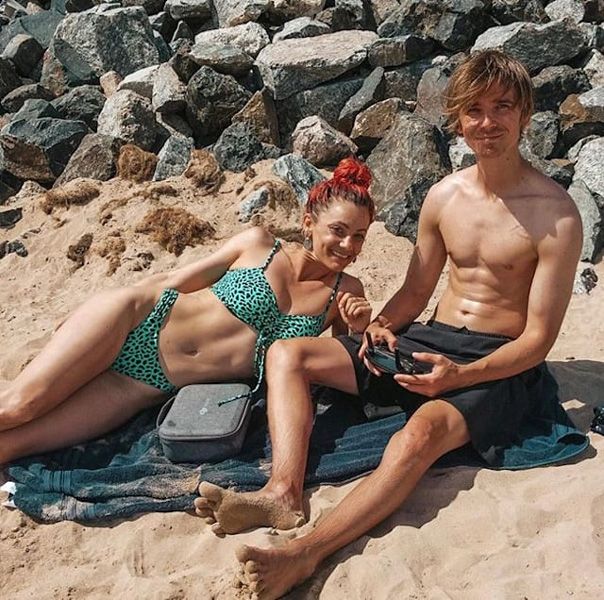 Dianne Buswell and Joe Sugg posing on the beach