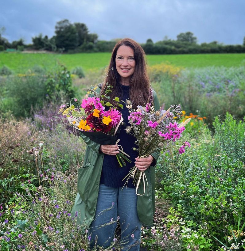 Rachel de Thame holding two bunches of flowers