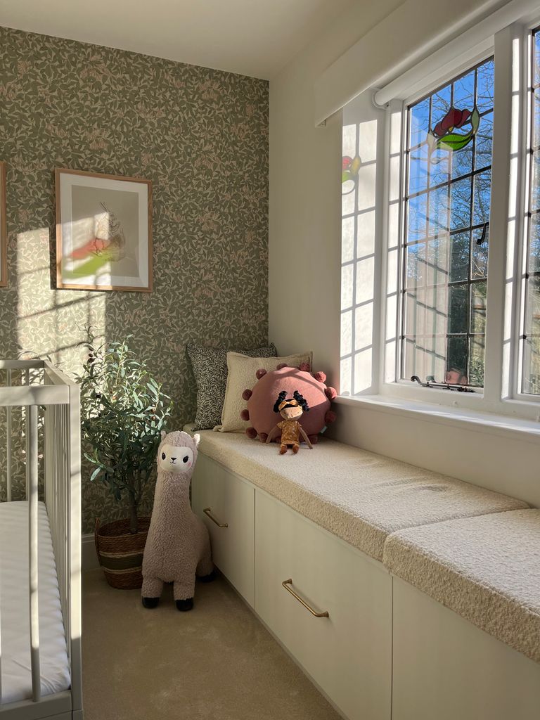 child's room with floral wallpaper, soft toys, under window storage