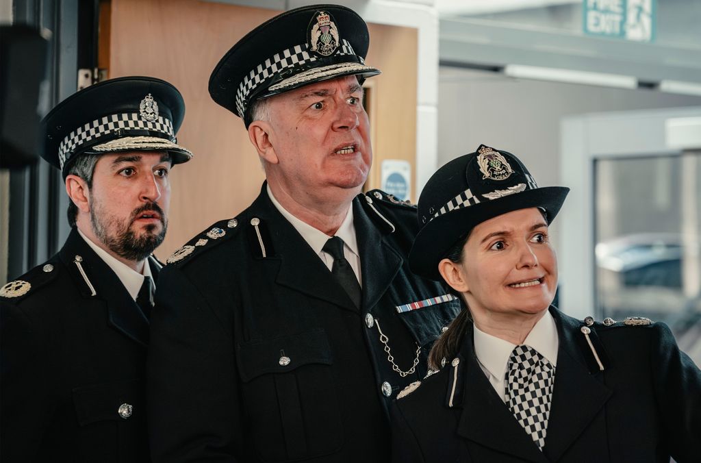 close-up of three police officers looking shocked