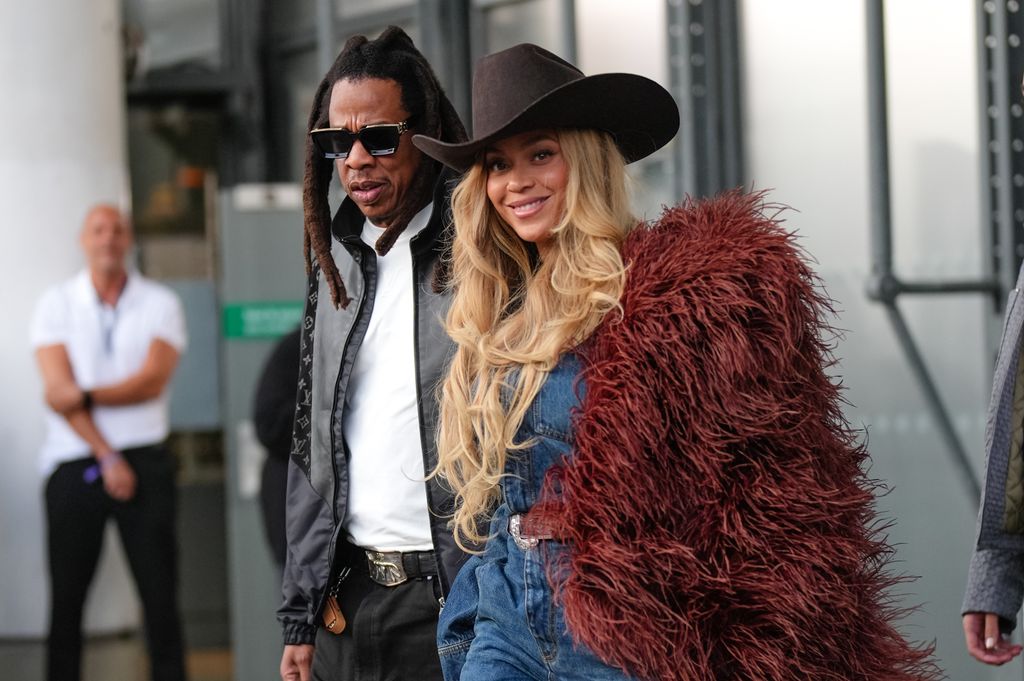 Jay-Z wears a black leather jacket with Louis Vuitton monogram logo print, a white t-shirt ; BeyoncÃ© Knowles / Beyonce wears a cowboy hat, a burgundy faux fur fluff coat on one shoulder, a blue denim shirt, during the Louis Vuitton Menswear Spring/Summer 2026 show as part of Paris Fashion Week on June 24, 2025 in Paris, France. (Photo by Edward Berthelot/Getty Images)