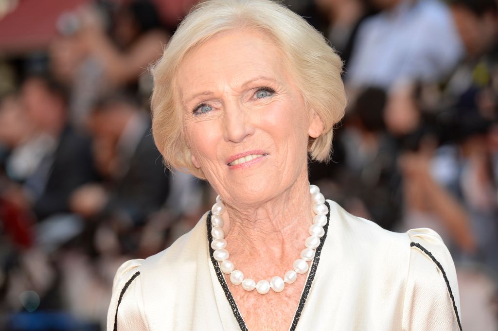Mary Berry in a white dress with a black trim and a pearl necklace