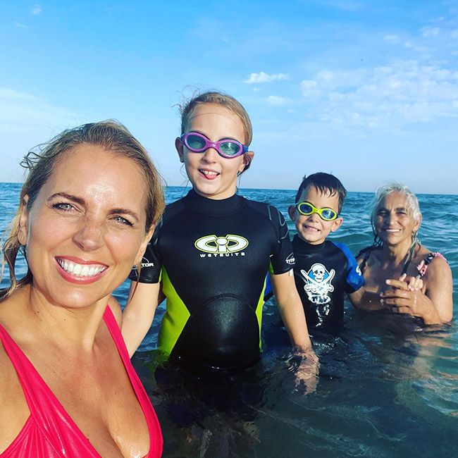 Jasmine Harman in a swimsuit posing with her two children and her mum