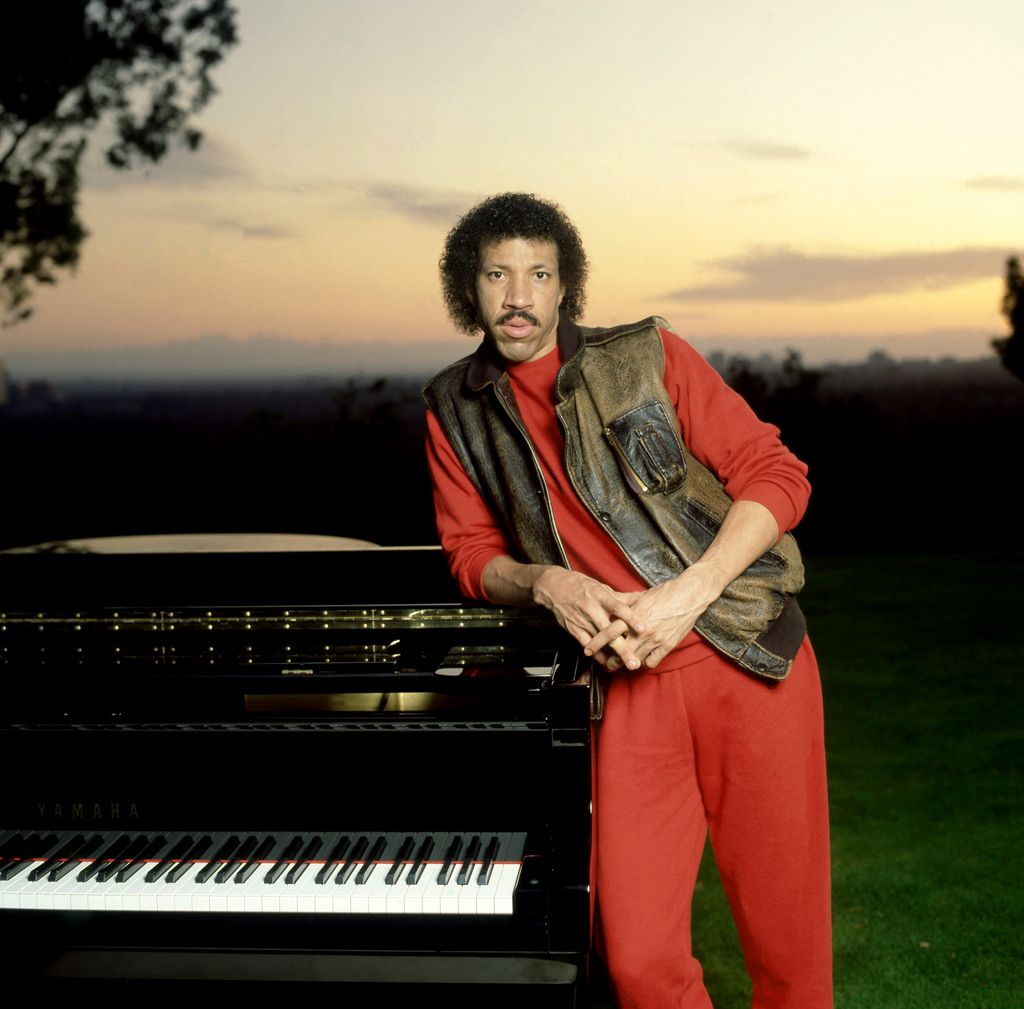 American singer Lionel Richie poses for a portrait with his piano and sunset in Los Angeles, California, circa 1983.