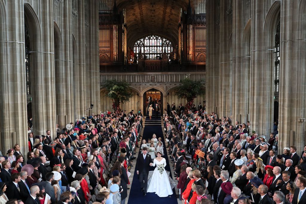 Princess Eugenie and Jack Brooksbank holding hands walking down the aisle