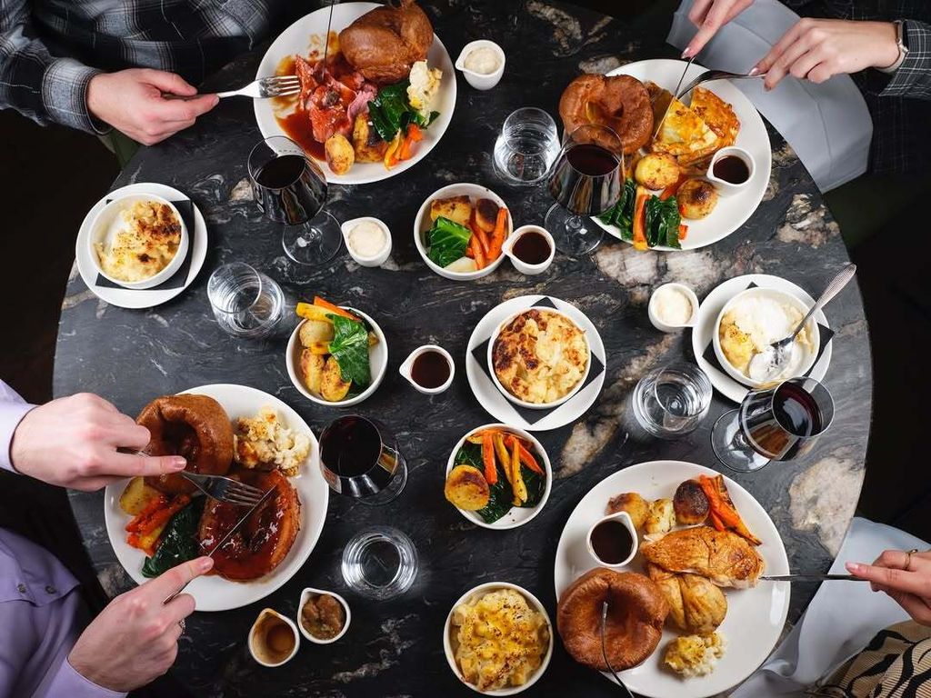 A Sunday roast on four plates shot from above