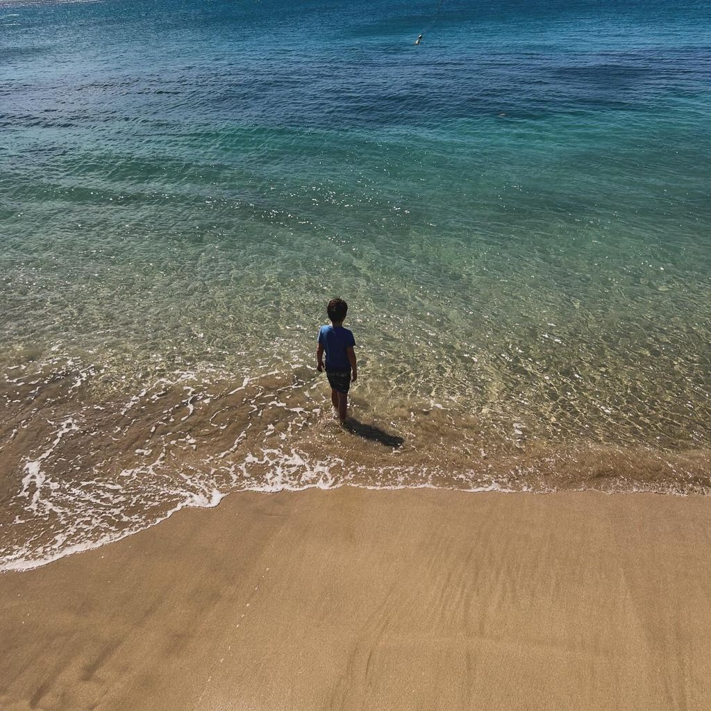 boy standing in sea 