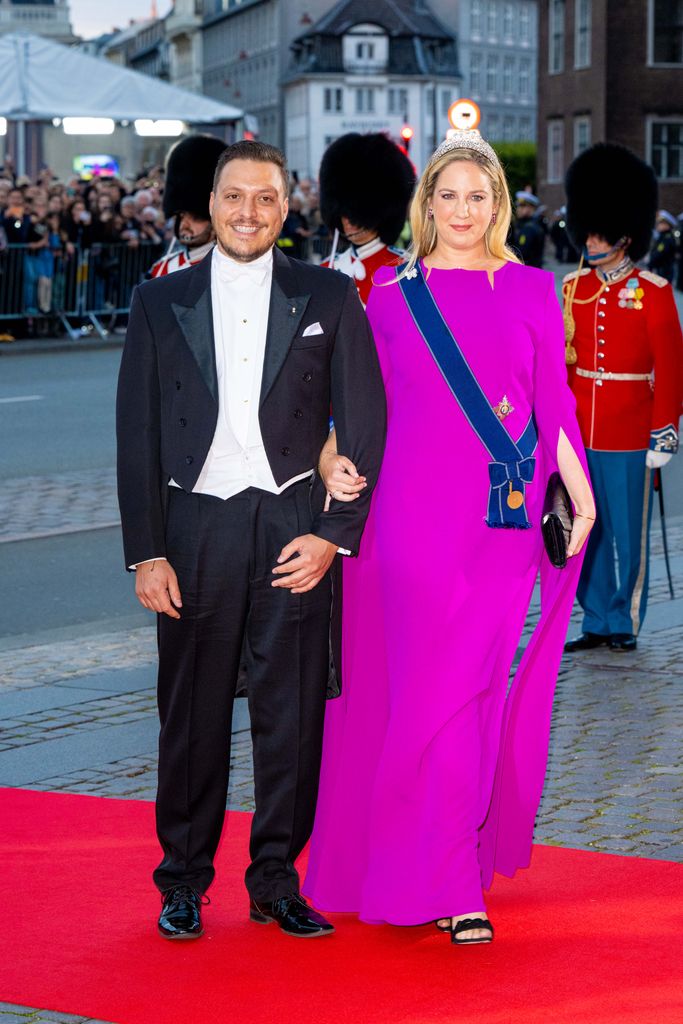 Matthew Kumar in a black suit and Princess Theodora wearing a pink dress