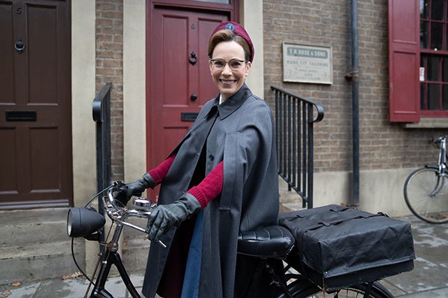 Laura Main as Shelagh Turner sits on a bike on Call the Midwife