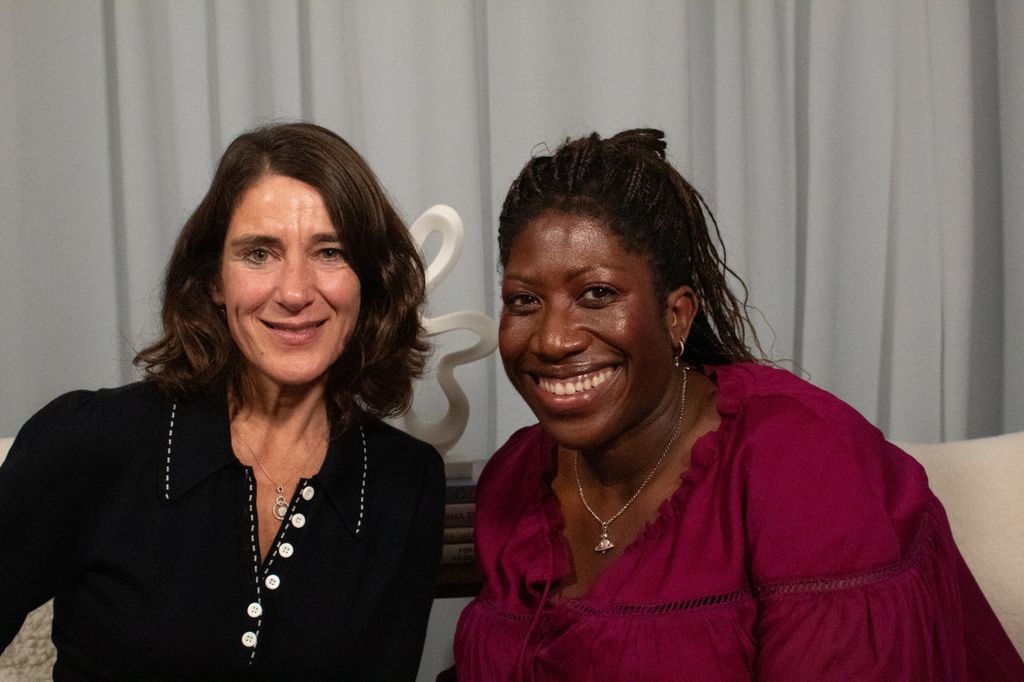 Two women smiling in a podcast studio
