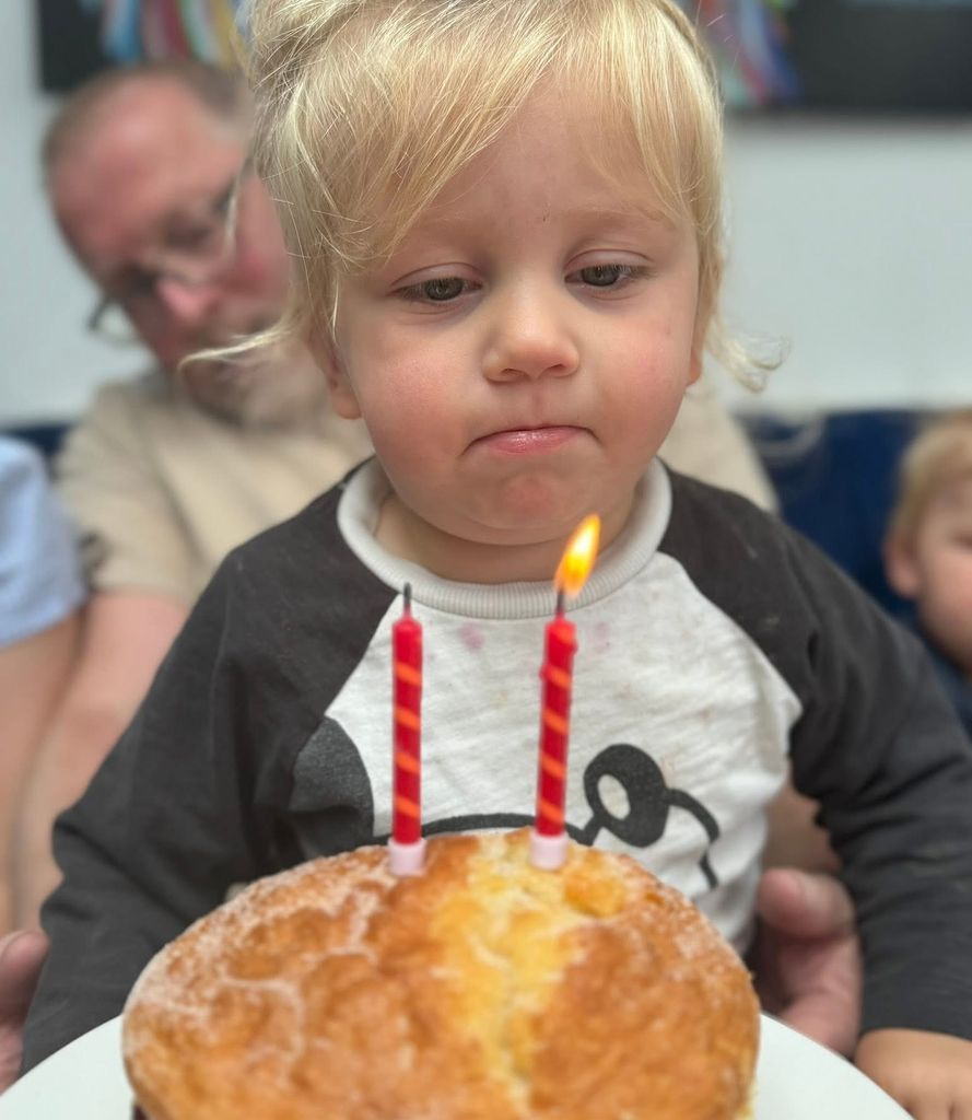 two-year-old blowing out birthday cake candles 
