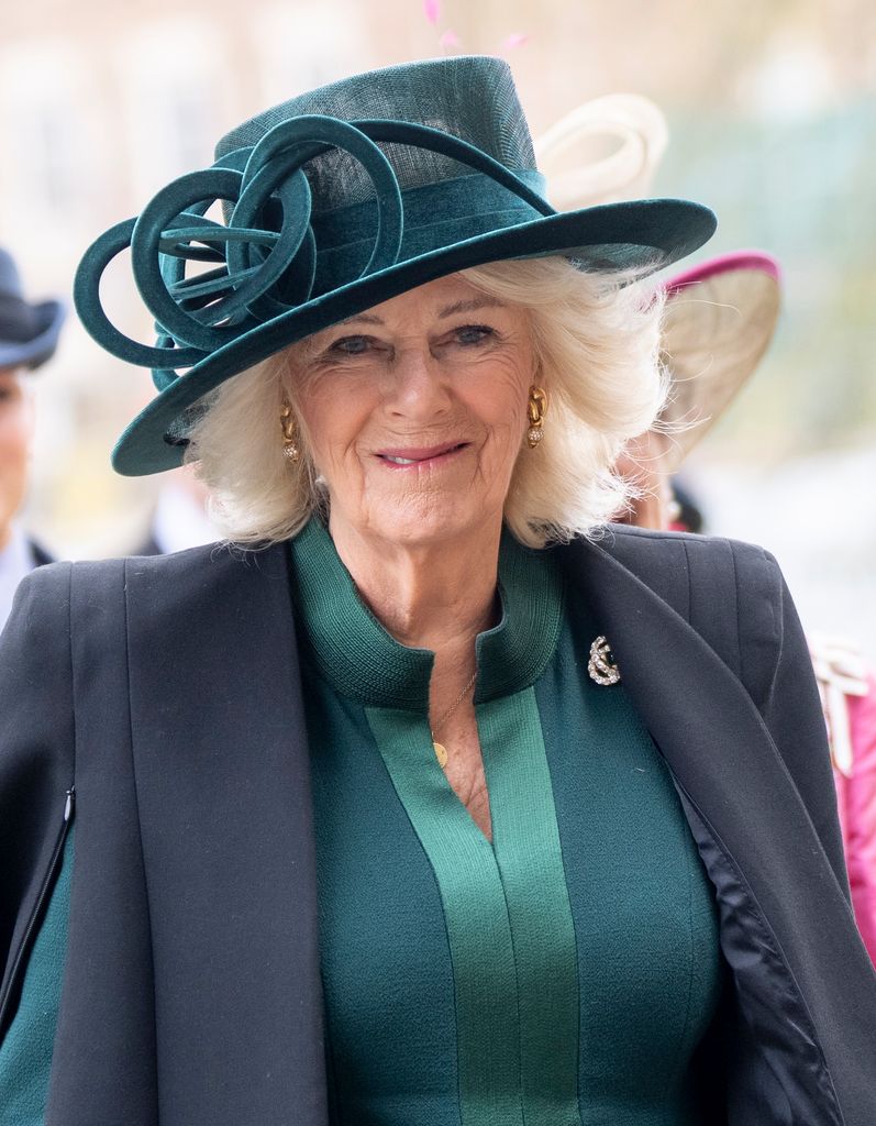 Queen Camilla wearing green dress and hat