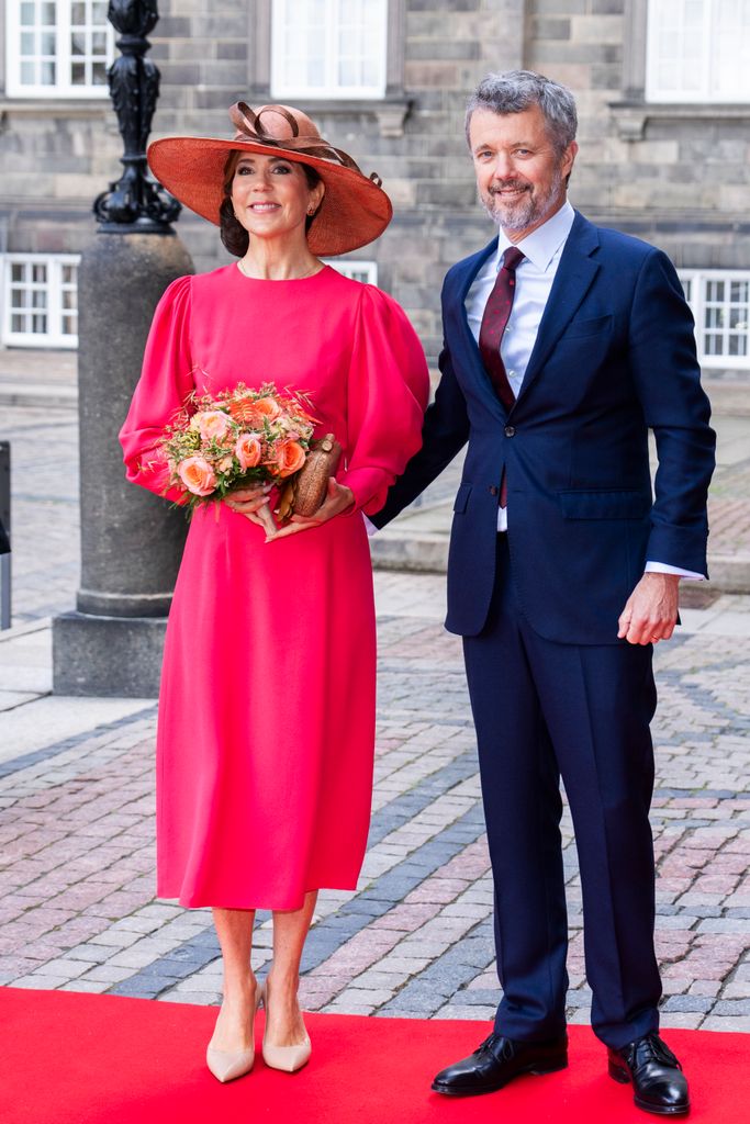 King Frederik in suit and Queen Mary in coral dress 