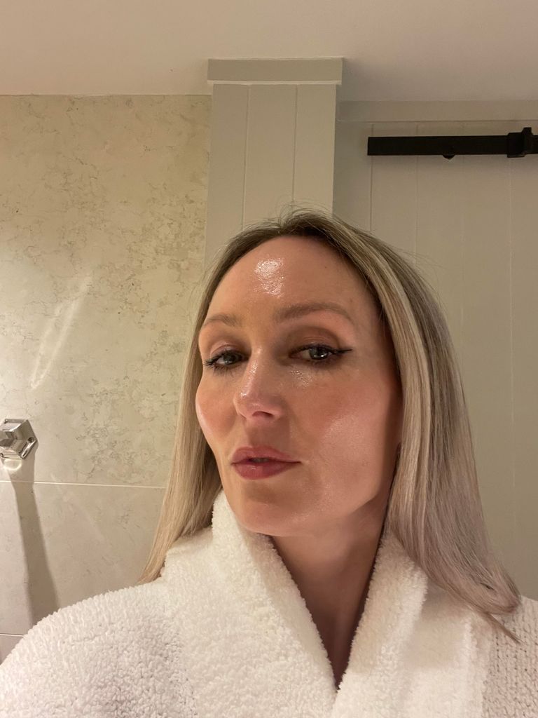 A picture of Cassie with very glossy, wet-look skin in a bathrobe