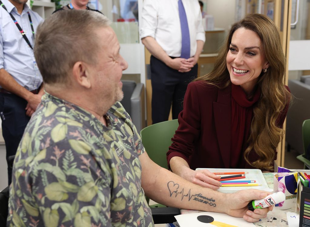Kate Middleton wearing burgundy and chatting to Pete Maclaine