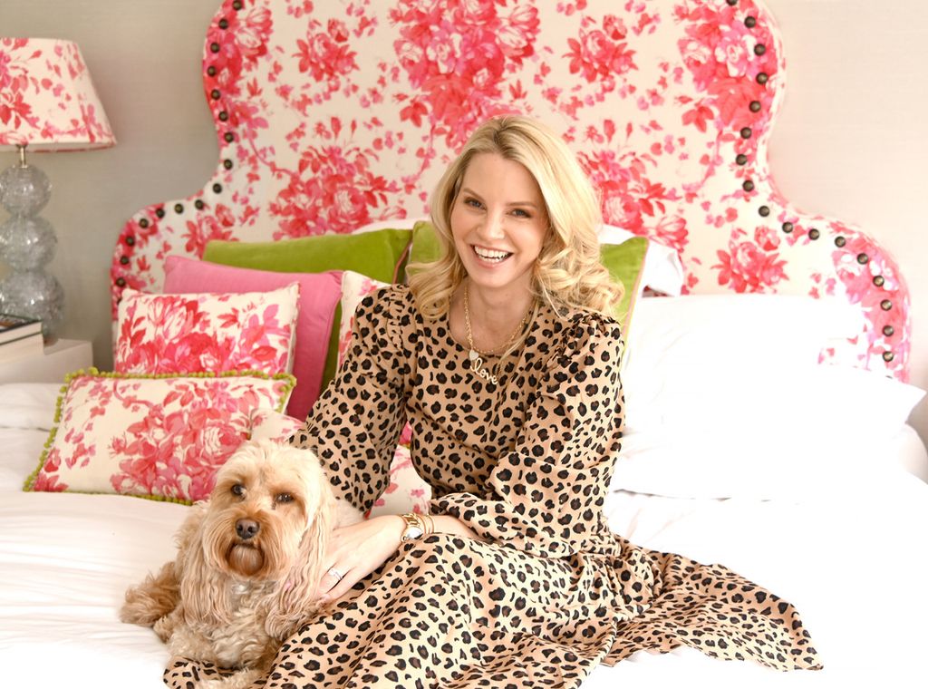 Woman sitting on a bed in a leopard print dress
