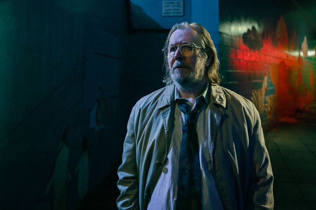 man wearing trench coat in dimly lit street