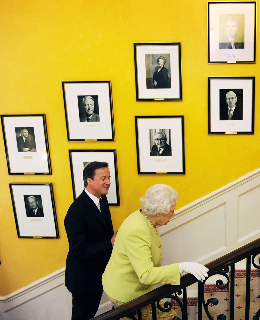 Britain's Queen Elizabeth II (R) and British Prime Minister David Cameron walk up the stairs at 10 Downing Street