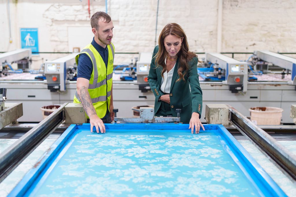 The Princess looks at printing machinery in operation with printer Matt Craven