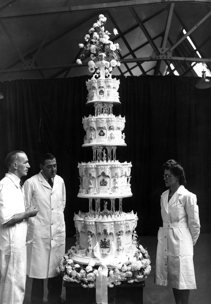 Black and white photo of three people in white coats inspecting Queen Elizabeth's '10,000 mile' wedding cake
