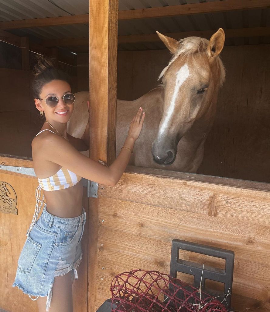 michelle patting horse in stable 