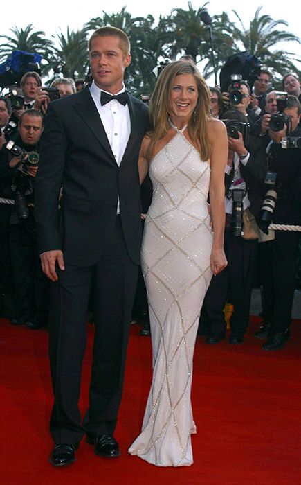 Jennifer Aniston wearing a long white Versace dress with Brad Pitt