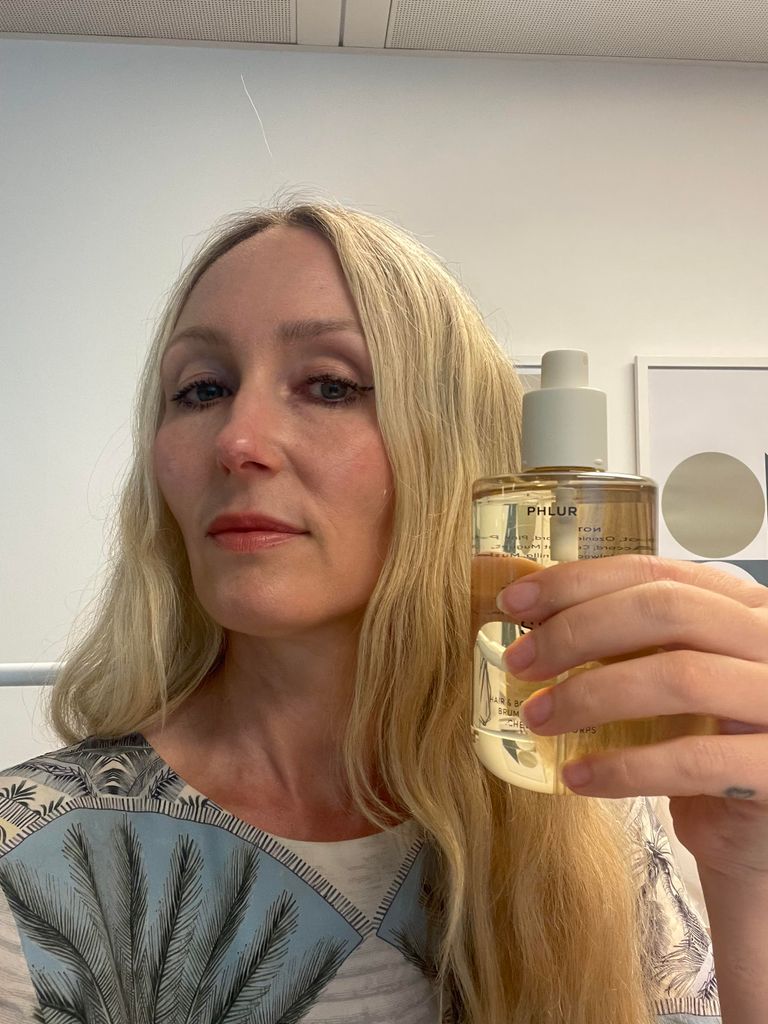 Cassie Steer is holding a bottle of Phlur Vanilla Skin body spray