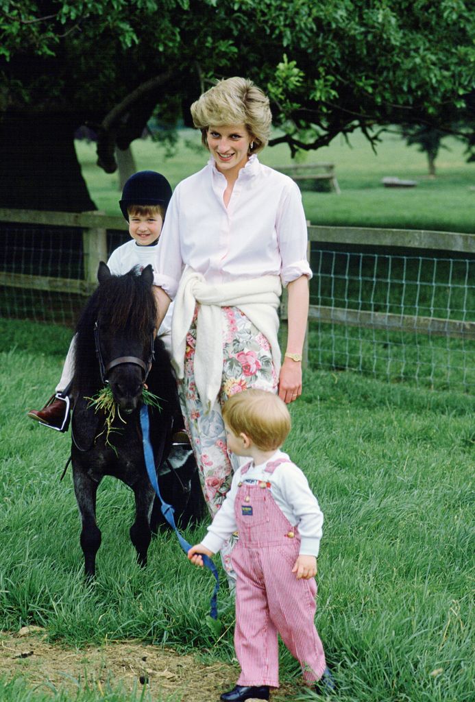 William riding on a pony with Diana and Harry in the garden