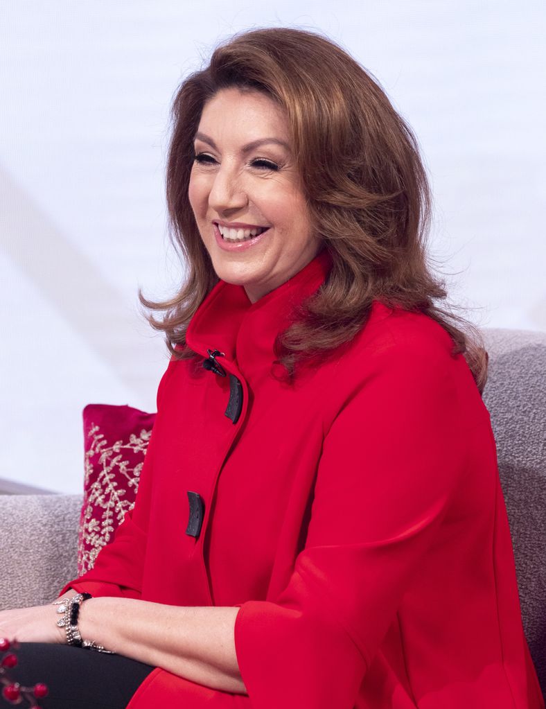 Jane McDonald smiling in a red coat