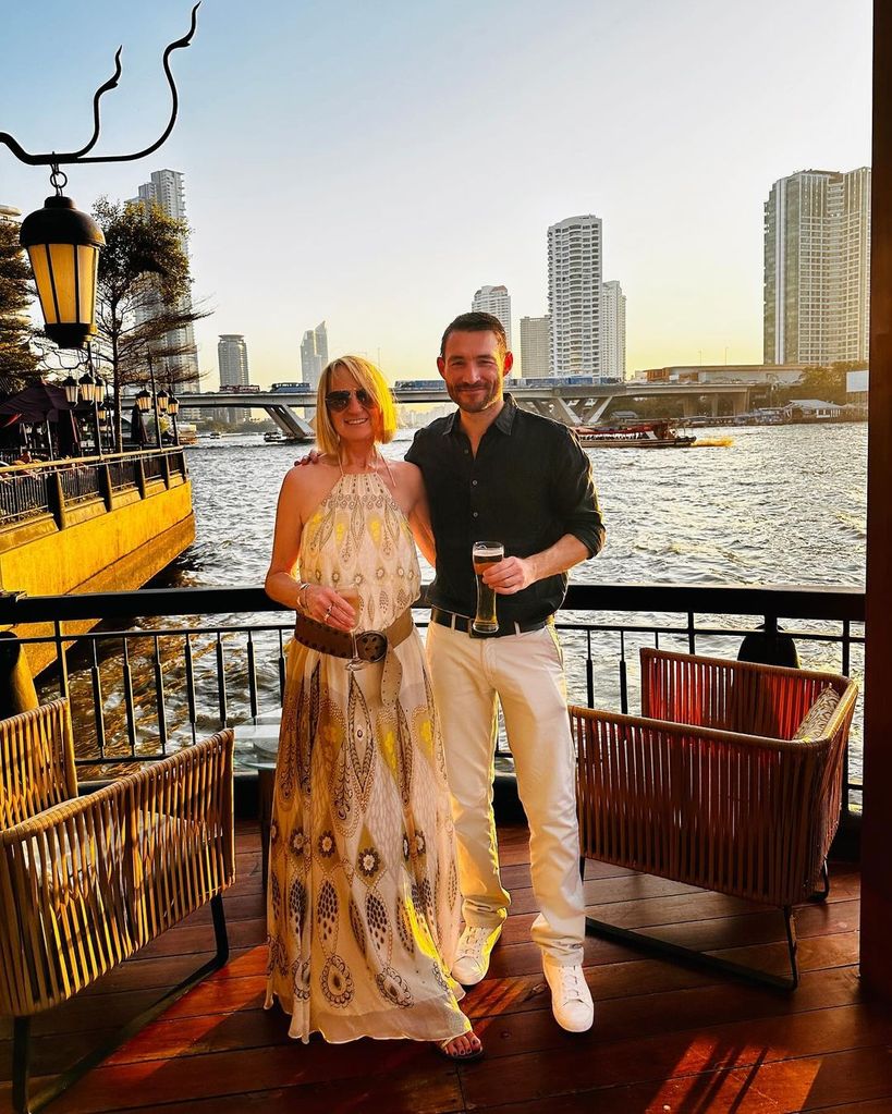 Carol McGiffin and Mark Cassidy holding drinks at sunset