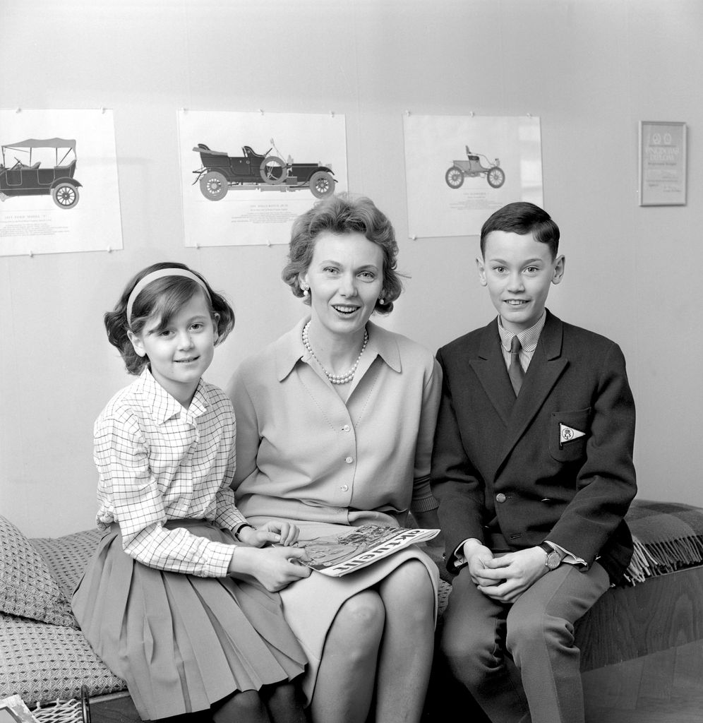 Black-and-white photo of Countess Marianne Bernadotte sitting on a bed with two of her children