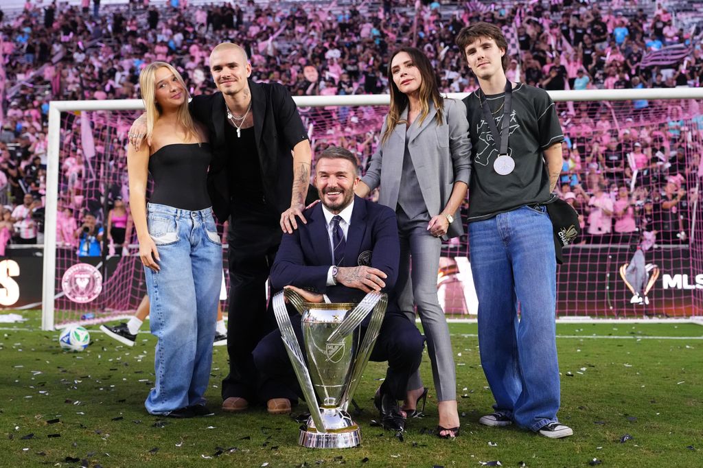 harper, david, cruz, victoria and romeo beckham pose with trophy on football field