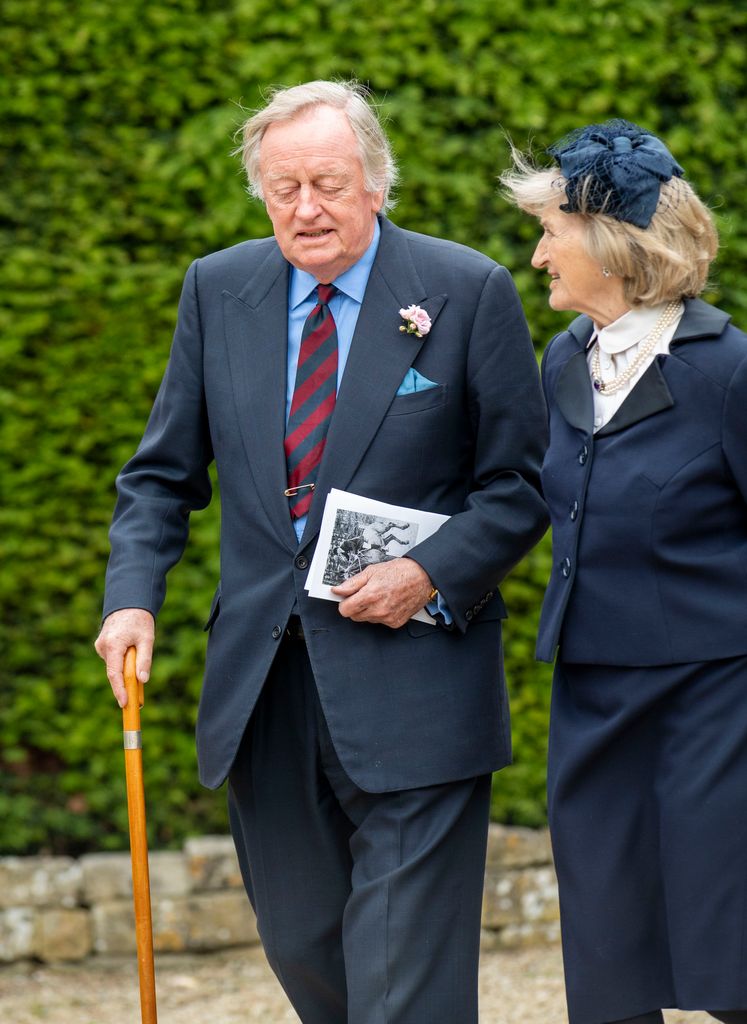 Andrew Parker Bowles walking with a woman and a walking stick