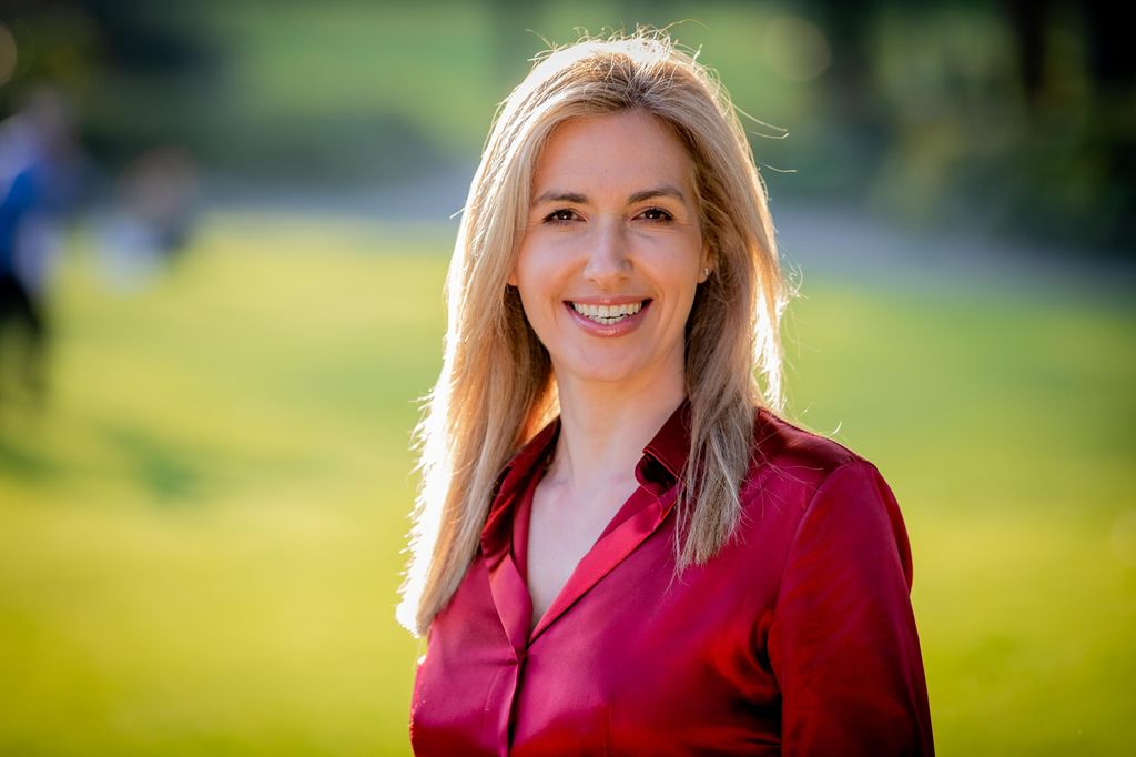 Woman in silky red shirt smiling 