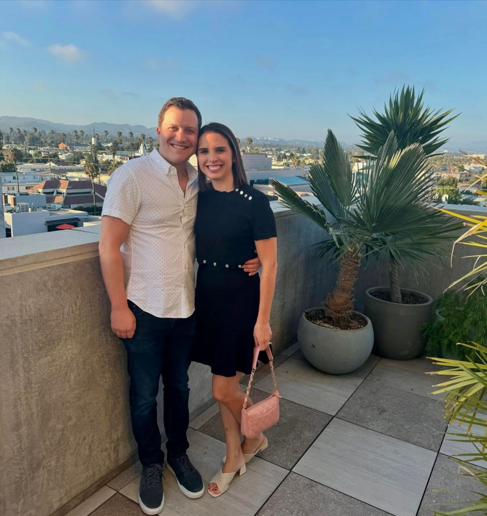 elizabeth schulze and husband michael kaplan posing on balcony by the sea