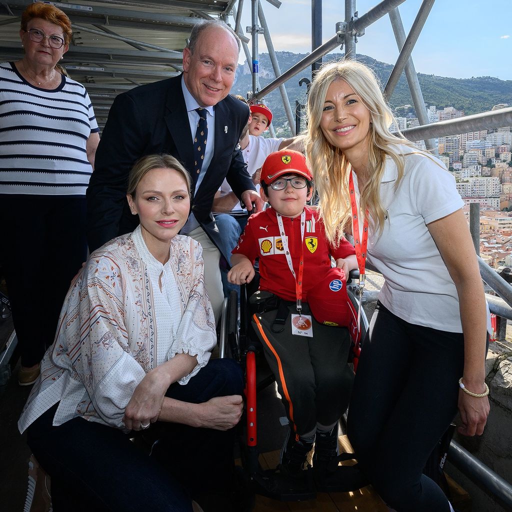Princesa Charlene Kwell al lado de un niño en una silla de ruedas, mujer y príncipe Albert